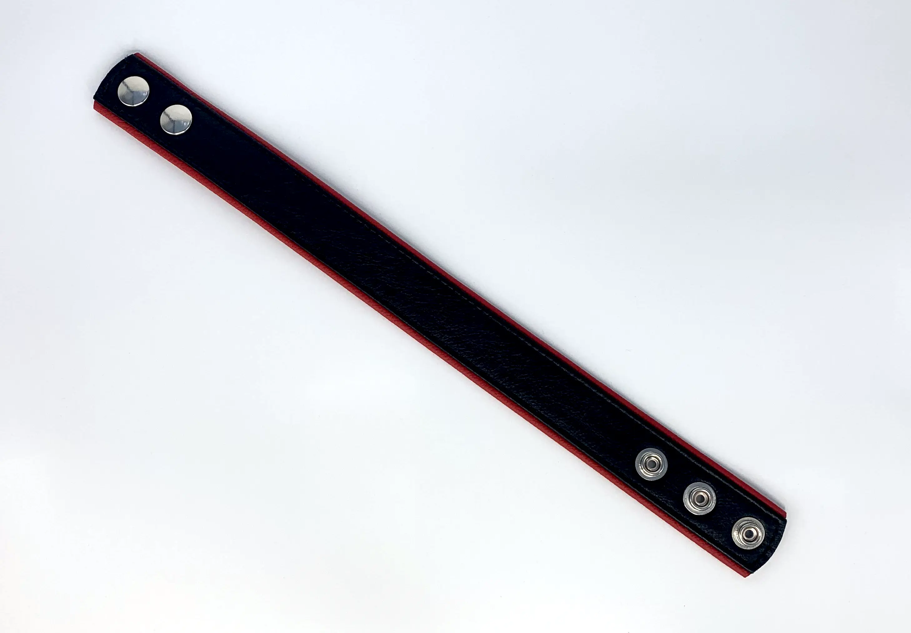 Schwarze Oberseite des Leder-Oberarmbands mit Druckknöpfen zur Weitenverstellung