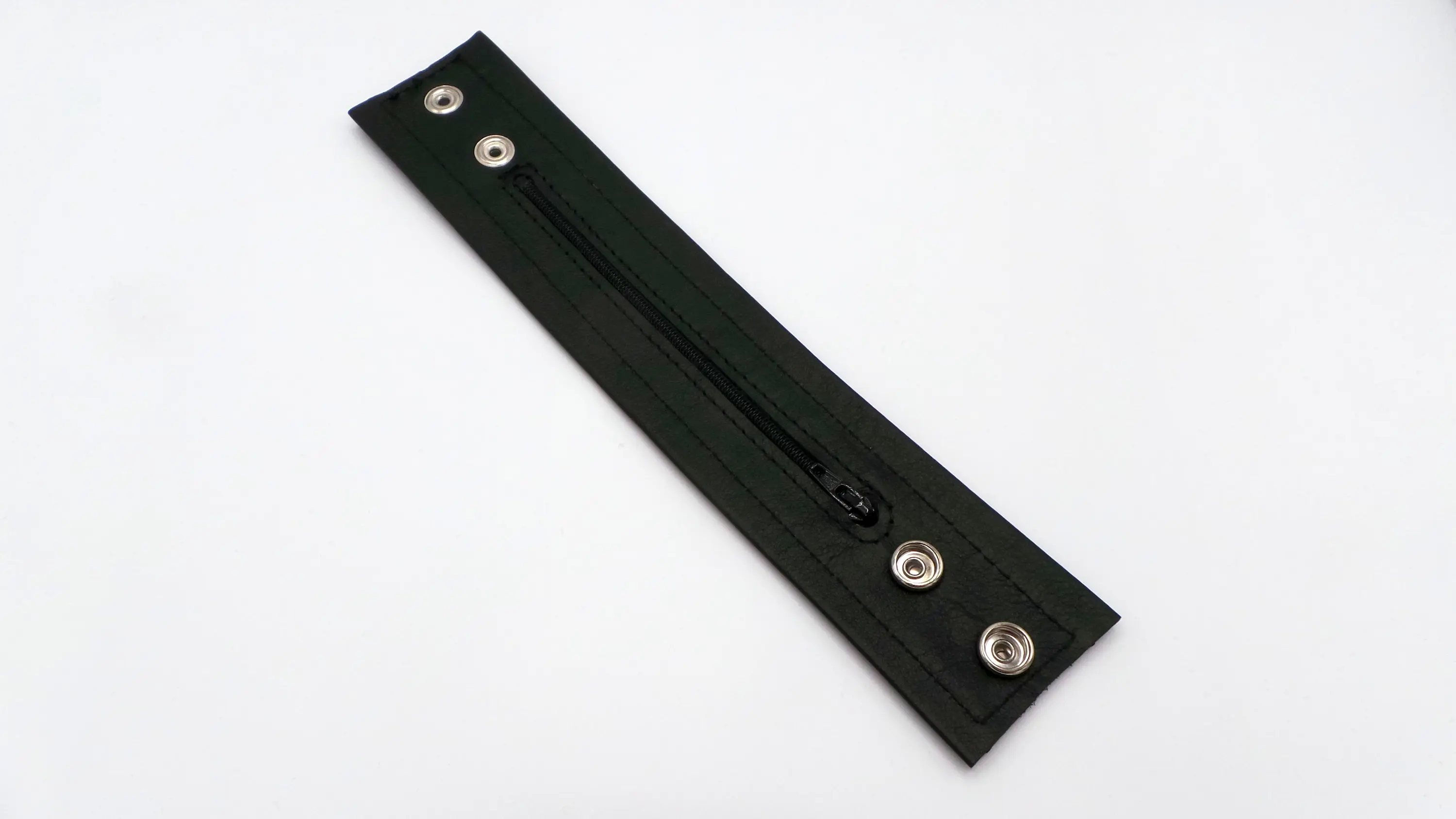 Innenseite des schwarzen Leder-Armbands mit schwarzem Reißverschluss-Geldfach und Druckknöpfen
