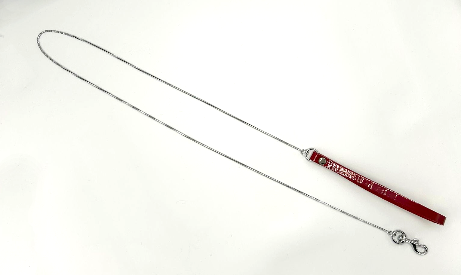 Draufsicht von silberner Führungskette mit roter Lacklederschlaufe